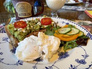 breakfast with avocado on toast, poached eggs and colorful tomatoes