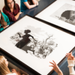 group sitting at table looking at artwork