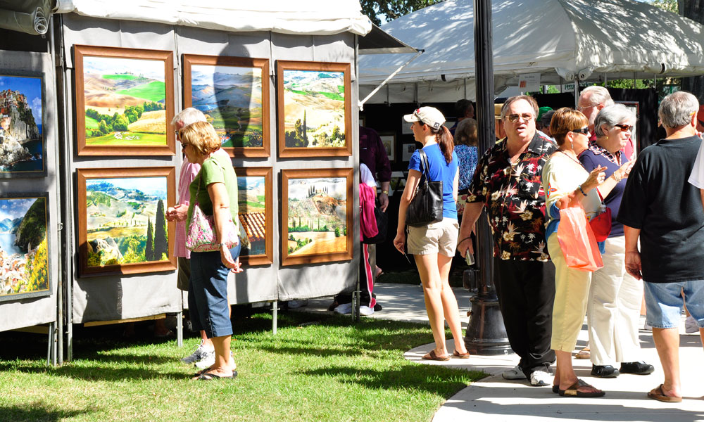 Winter Park Autumn Art Festival booth with paintings and patrons.