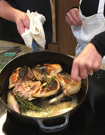 chef and student cooking chicken