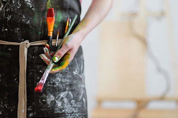 artist holding brushes